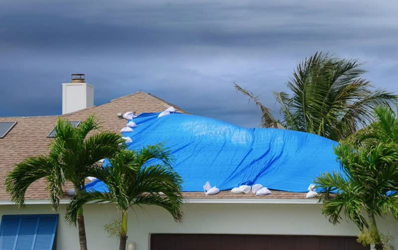 Florida home with blue tarp after hurricane damage