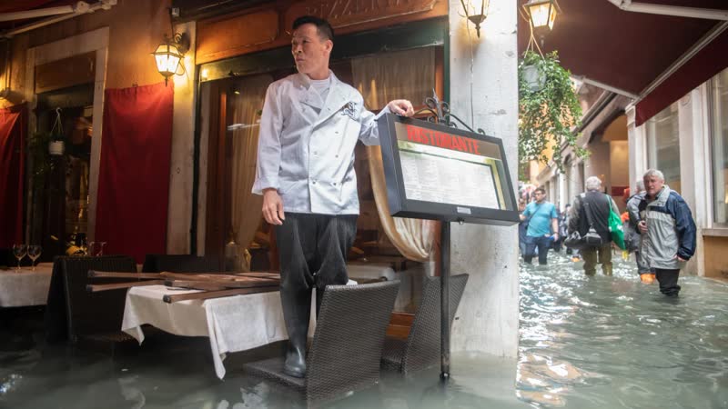 Commercial property flooding - business owner standing in flood water